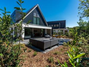 登堡Energy neutral villa with wellness area的现代房子,在庭院设有游泳池