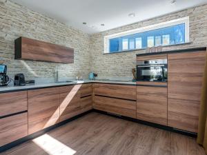 登堡Energy neutral villa with wellness area的厨房配有木制橱柜和砖墙