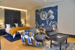 比勒陀利亚Apogee Boutique Hotel & Spa的一间卧室配有一张床、一张沙发和椅子