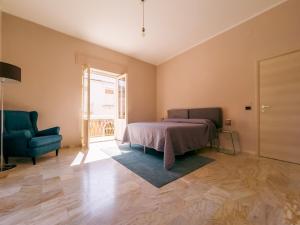 锡拉库扎FICU PALACE的卧室配有床、椅子和窗户。