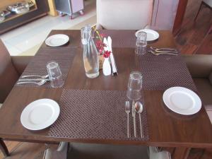西姆拉Regenta Resort & Spa Mashobra的一张带白板和银器的木桌