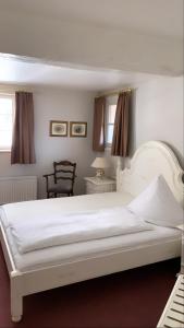 AmöneburgDombäcker的卧室配有白色的床和椅子