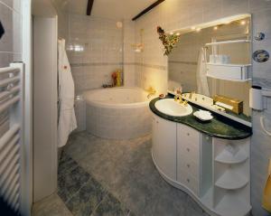 布科伽斯特豪斯涛博尔穆勒酒店的带浴缸、水槽和浴缸的浴室