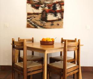 卡萨雷斯The Wild Olive Andalucía Citrus Suite的一张带椅子的木桌和一碗水果