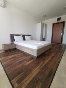 巴尔New Luxury Apartments BaR的卧室铺有木地板,配有一张大床