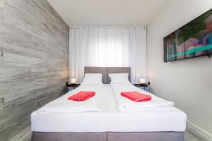 萨比诺瓦Dobre smaki at Wczasowa8 sea resort的卧室配有白色床和红色毛巾