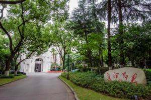 上海上海汾阳花园酒店的一条在白色建筑前方的树木街道