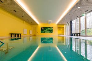 柏林施罗斯公园酒店的游泳池铺有蓝色瓷砖地板,拥有黄色的墙壁