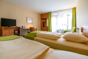 柏林施罗斯公园酒店的酒店客房设有两张床和一台平面电视。