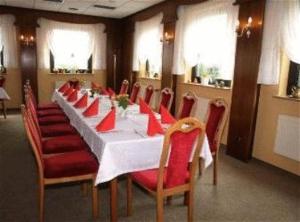 Niederfinow阿姆施夫瑟贝沃克酒店的一间带长桌和红色椅子的用餐室
