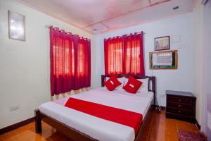大雅台OYO 741 Sierra Travellers Inn的一间卧室配有一张带红色窗帘的大床