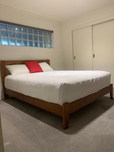 卡塔尼Quayside Luxury Apartments的一间卧室配有一张带红色枕头的大床