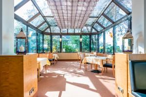 柏林施罗斯公园酒店的餐厅设有玻璃天花板和桌椅