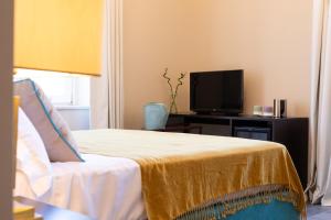 蒙德罗Villa Masetta - Luxury Suites的一间带床和电视的客厅