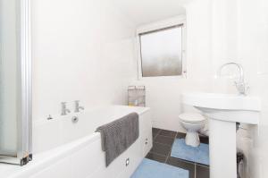 阿伯丁Aberdeen Quiet City Apartment, Ferryhill的白色的浴室设有浴缸、水槽和卫生间。