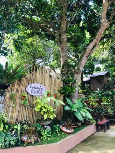 大雅台Felicitas Tagaytay的种植了植物的花园和带标志的栅栏