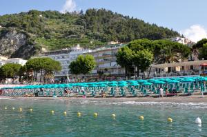 马奥莱全景酒店的一个带椅子和遮阳伞的海滩和一家酒店