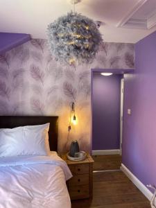 斯卡伯勒The Black Swan Hotel的一间卧室配有一张床和紫色的墙壁