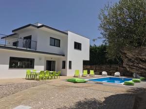 FeteiraCasa Verde的一个带游泳池和绿色椅子的别墅