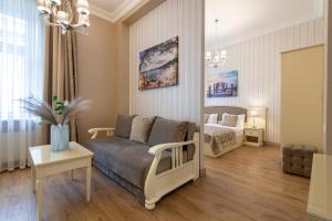 利沃夫Royal mini-apart hotel on Rynok Square的客厅配有沙发和1张床