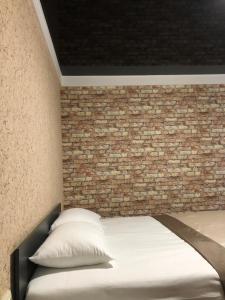 哈尔科夫Bloom Hotel的一间卧室设有砖墙和一张床