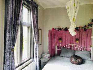 阿沃斯塔2-Bed Apartment overlooking the river的一间卧室配有一张床和粉红色窗帘