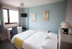 邓坎嫩Fort Conan Hotel的蓝色的卧室设有床和窗户