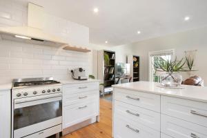 开普敦Magnolia Cottage的厨房配有白色橱柜和炉灶。