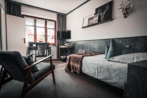 赖兴巴伊姆福格特兰Sommers Hotel Altes Posteck的一间卧室配有一张床和一把椅子
