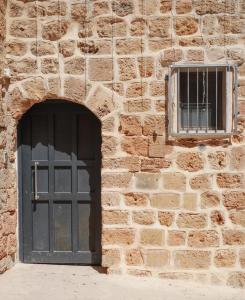 阿卡تاج عكا Taj Akko的砖砌的建筑,有门和窗户