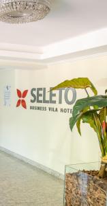 沃尔塔雷东达Seleto Hotel的墙上挂着植物的酒店标志