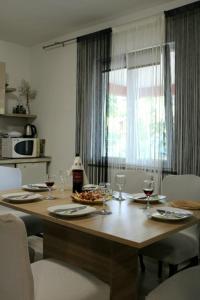 扎达尔Apartman Marta的餐桌,配有酒杯和食物