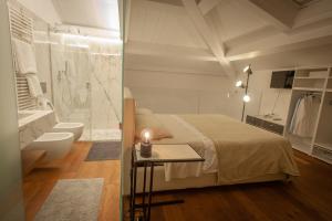 阿奇卡斯泰洛Mori Siciliani House的一间卧室配有一张床,浴室设有浴缸