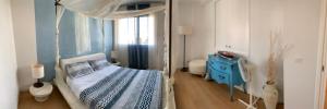 利多迪耶索罗Heron apartments的一间卧室配有天蓬床和蓝色橱柜
