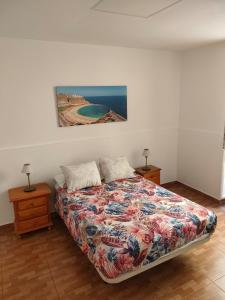 大加那利岛拉斯帕尔马斯Apartamento La Marea的卧室配有一张床,墙上挂有绘画作品