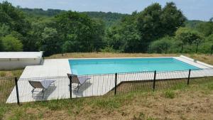 GeauneLa maison de Demeter, 10 min d'Eugénie, calme des Landes Intérieures的一个带两把椅子的田野游泳池