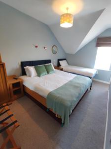 班多伦Rolling Wave Guesthouse的一间卧室设有两张床、一张桌子和一个窗口