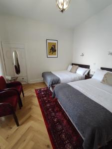 班多伦Rolling Wave Guesthouse的一间带两张床的卧室和红色地毯