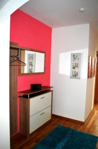 法克湖斯赫利特威瑟公寓的一间设有红色墙壁和梳妆台的房间