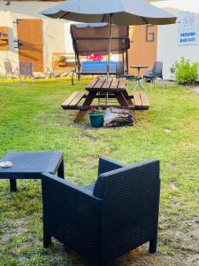 BoimortoAlbergue-Hostel Casa da Gandara的草上野餐桌和带雨伞的长凳