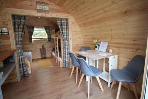 多尔盖罗Glamping Huts in Heart of Snowdonia的小木屋内的房间,配有桌椅