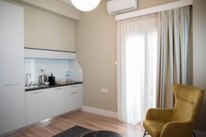 约阿尼纳CityScape Luxury Apartments的厨房配有椅子、桌子和窗户