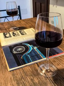 巴德希La dimora del Murales - Holiday home的坐在桌子上的一杯红葡萄酒