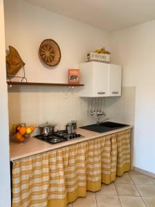 巴德希La dimora del Murales - Holiday home的厨房柜台配有炉灶上的锅碗瓢盆