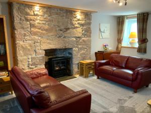 因弗内斯No 10 The Cottage的带沙发和石制壁炉的客厅