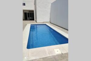 梅里达Apartamentos NayDa Gran casa con piscina的室内的蓝色海水游泳池