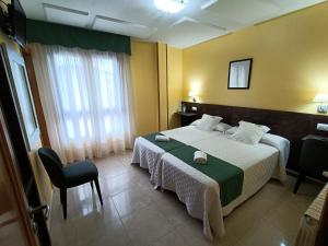 帕拉斯德丽Hotel Casa Benilde的配有一张床和一把椅子的酒店客房