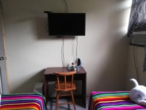 Antiguo CuscatlánHotel Antiguo的客房设有书桌、椅子和电视。