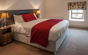 TyrrellspassNew Forest Estate Lodges的一间卧室配有一张带红色毯子的大床