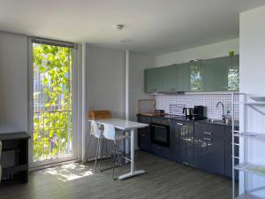 因斯布鲁克Holidayhome OMYXL的厨房配有蓝色橱柜、桌子和窗户。